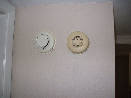 Electric smoke detector beside photoelectric smoke alarm