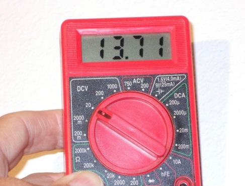 Cen-Tech 7 Function Digital Multimeter with 7-Segment LCD Display Testing a Battery Voltage